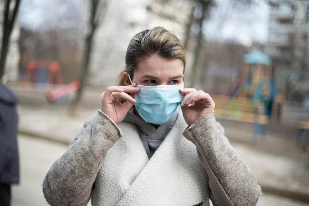 Mujer usando mascarilla para prevenir enfermedades respiratorias, recomendación para pacientes oncológicos