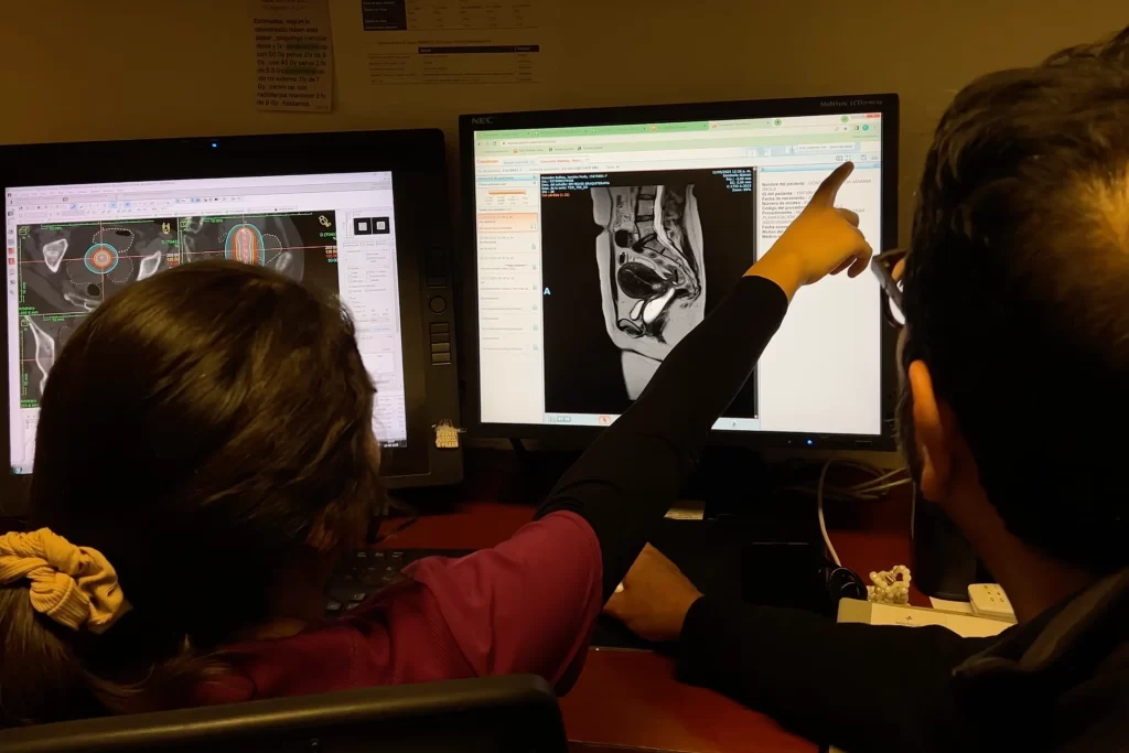 Profesionales de ROS Clínica Oncológica evaluando imágenes radiológicas con inteligencia artificial para planificación de radioterapia