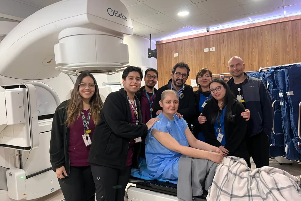 Equipo médico y paciente celebrando tratamiento de radioterapia en Clínica Oncológica ROS de Concepción
