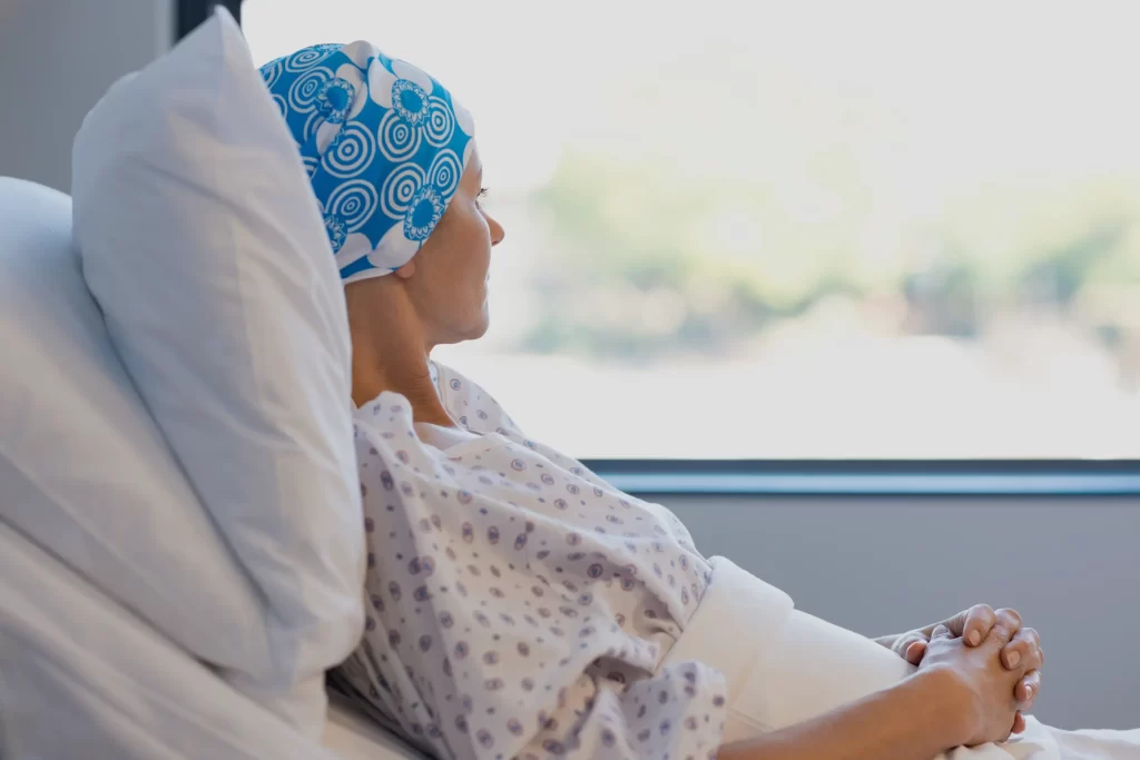 Mujer con cáncer observando por la ventana en centro oncológico en Chile, contexto de estadísticas del cáncer en Chile 2030