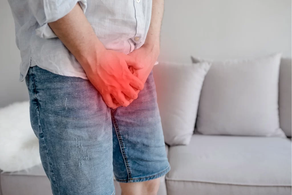 Hombre con dolor en la zona pélvica, una señal de alerta común asociada al cáncer de próstata tratado con radioterapia.