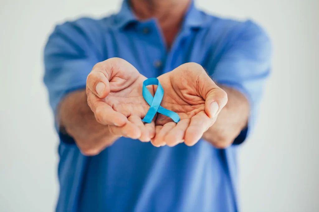 Hombre sosteniendo una cinta azul, símbolo de concienciación sobre el cáncer de próstata y la importancia de la radioterapia para cáncer de próstata.