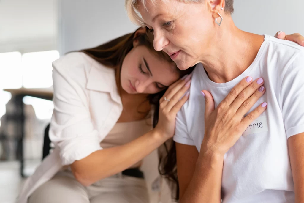 Mujer mayor y joven abrazadas en señal de contención emocional frente al cáncer de mama