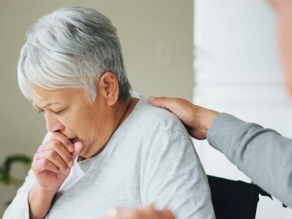 Persona con tos y dificultad respiratoria debido al humo en contexto de emergencias ambientales