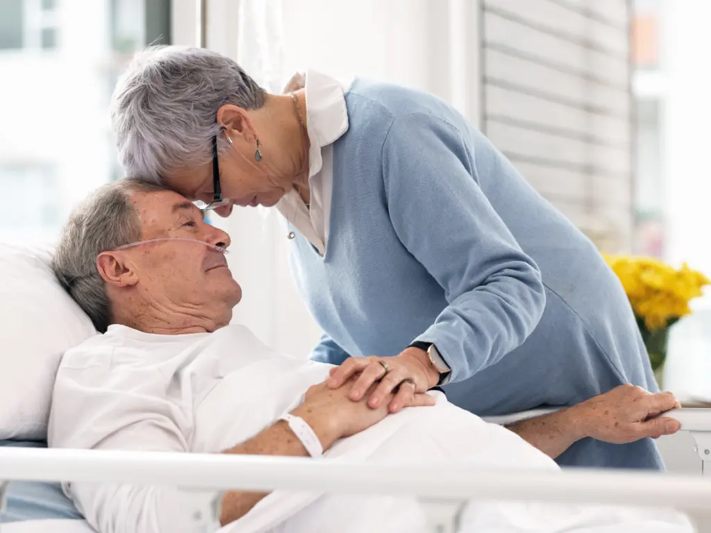 Paciente oncológico acompañado por su pareja durante una hospitalización, reflejando el apoyo familiar en el Día Mundial contra el Cáncer.