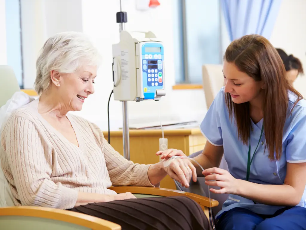 Paciente recibiendo tratamiento de cáncer en Concepción acompañada por personal de salud